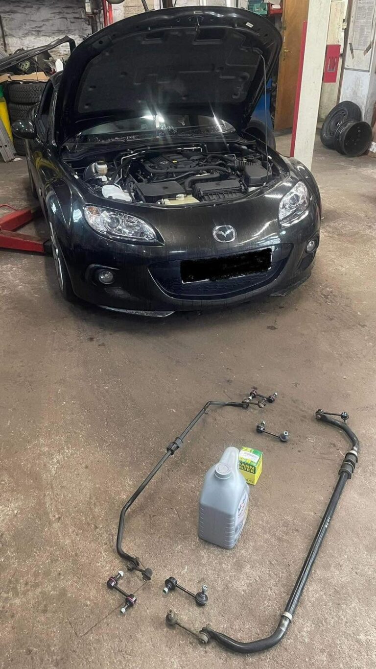A sports car in the workshop with the bonnet up