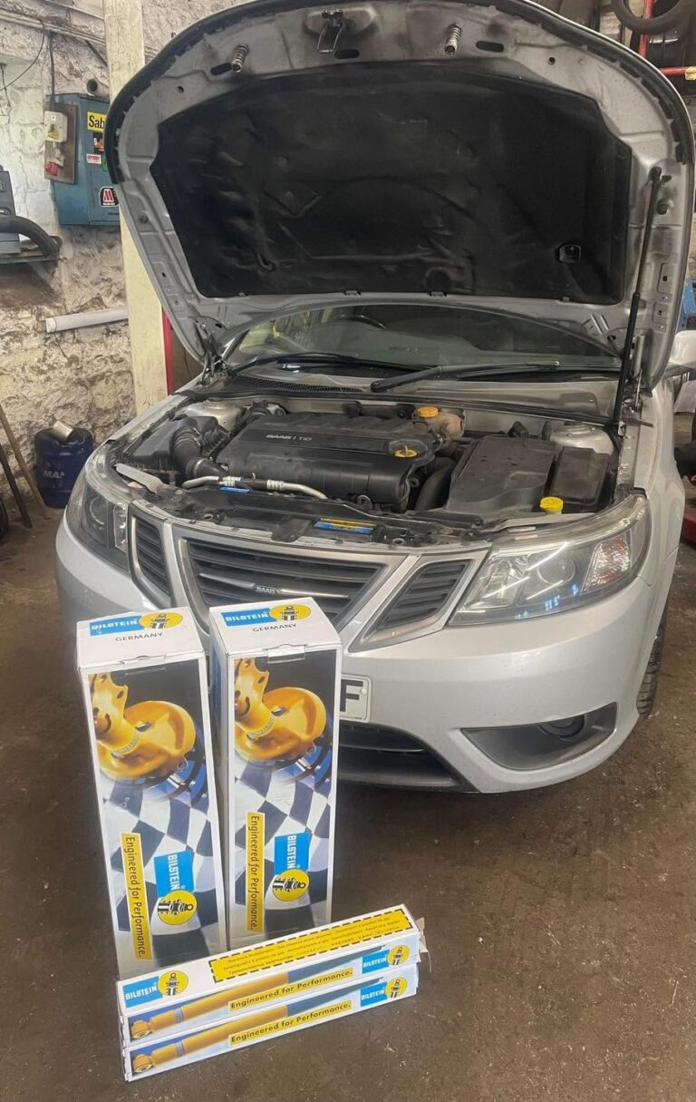 A car in the workshop with new suspension parts ready to fit