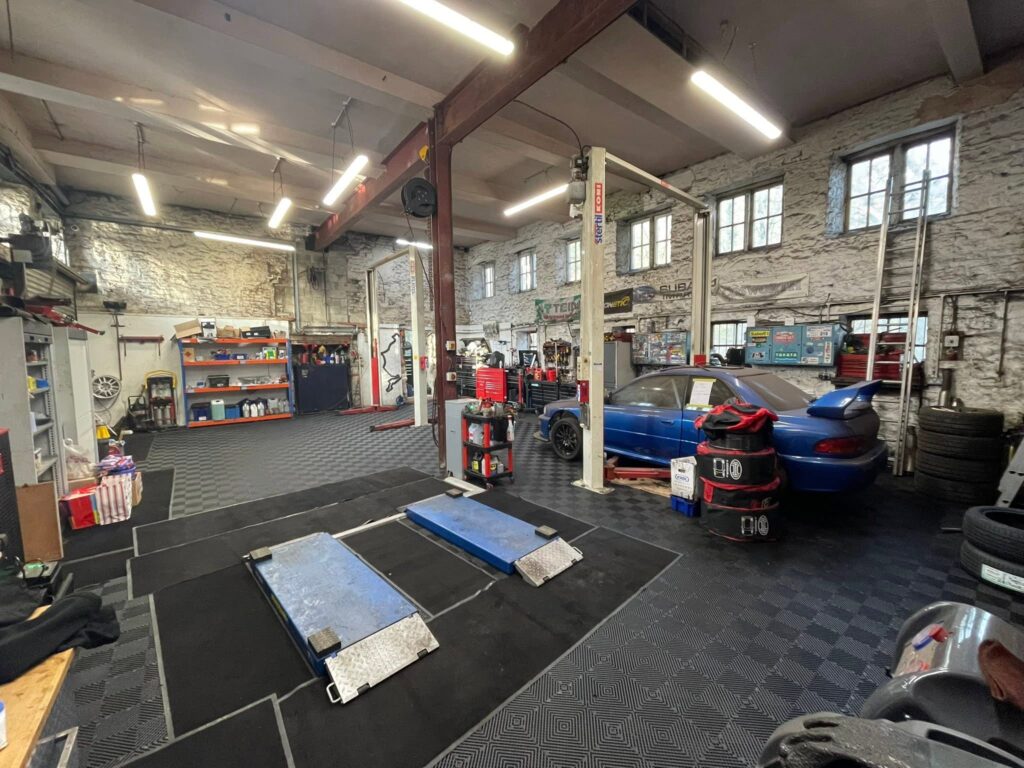 Inside the Woodside Garage workshop in New Mills, with cars on the ramps